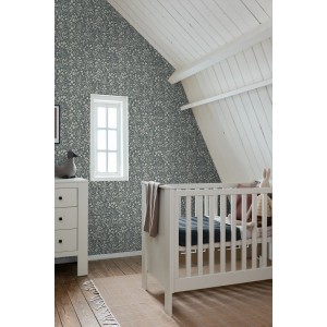 ESTAhome Vliestapete mit blaugrünem Blumenmuster an der Wand eines Kinderzimmers mit Babybett.
