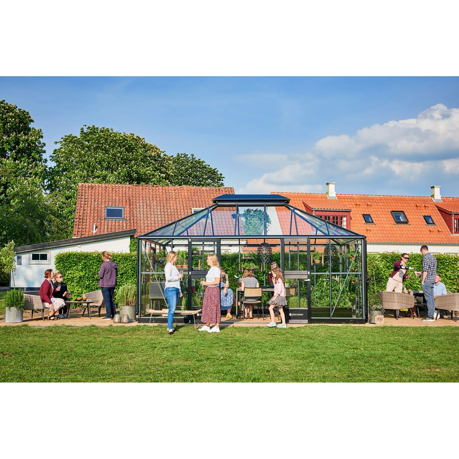 Großes, anthrazitfarbenes Juliana Gewächshaus Grand Oase 18 mit Fundamentrahmen im Garten.