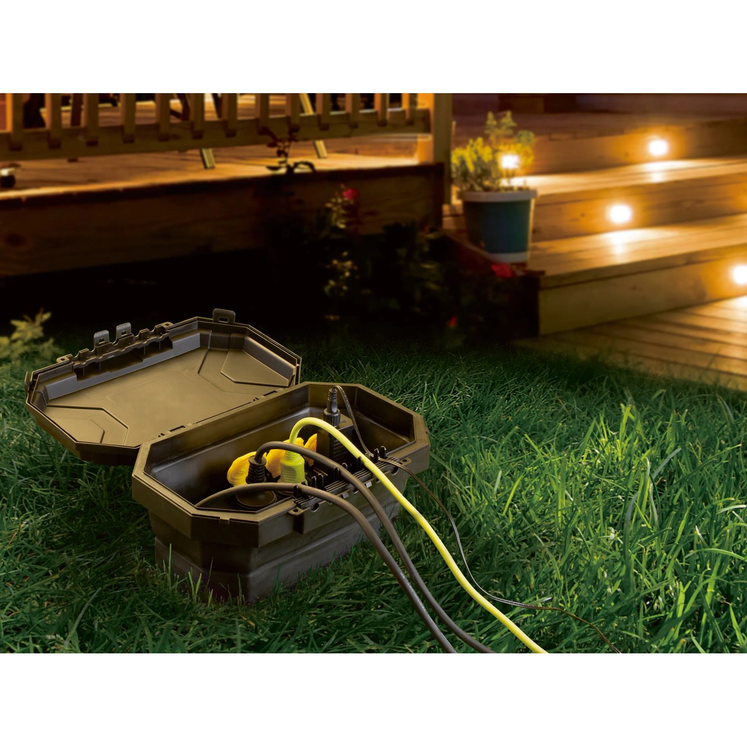 Geöffnete, faltbare D-Line Wetterschutzbox mit Steckdosen und Kabeln im Garten.