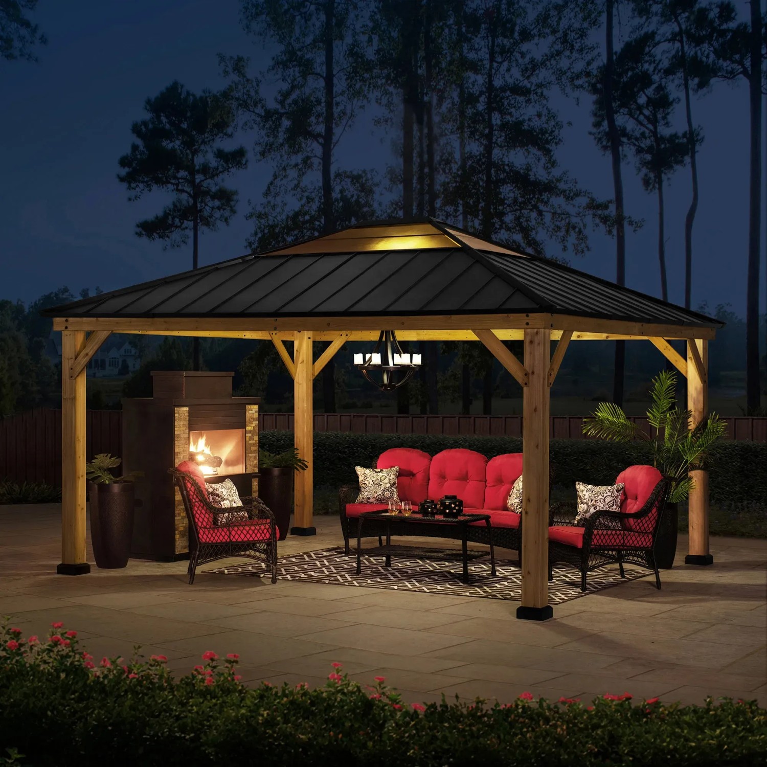 Anthrazitfarbener Sunjoy Gazebo Ernir aus Zedernholz (393x452cm) mit Möbeln und Kamin.