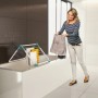 Frau hängt Wäsche auf SuperDry Wing Wäscheständer in Mint. Kompakter Wäschetrockner für Bad und Balkon.