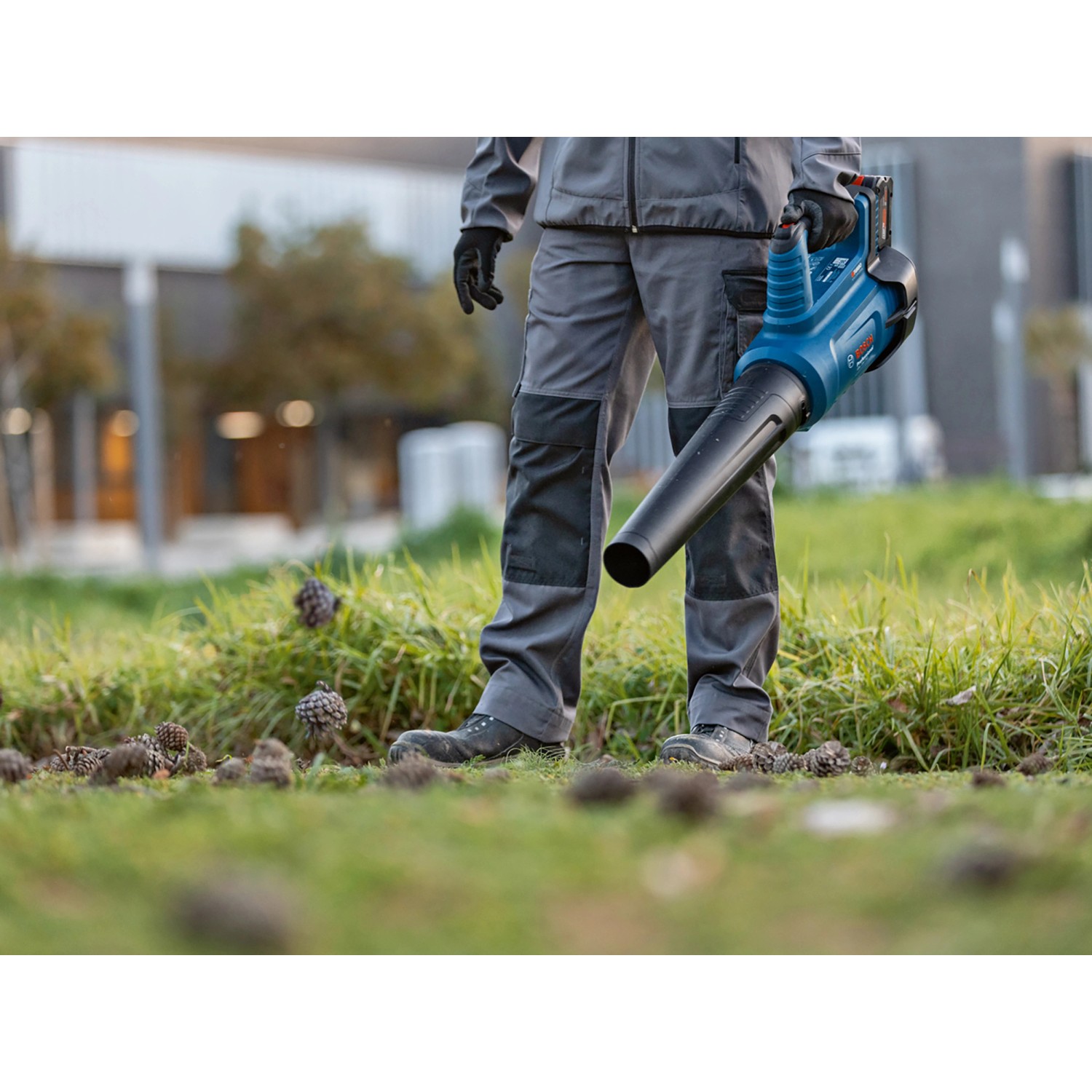 Bosch Professional Akku-Laubbläser GBL 18V-750 im Einsatz zum Laubbeseitigen auf Rasenfläche.