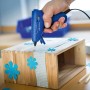 LUX Heißklebepistole im Einsatz beim Basteln mit Holz und blauen Deko-Blumen.