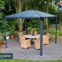 Canopia Gartenpavillon Palermo 3x3 in Anthrazit mit Tisch und Stühlen im Garten.