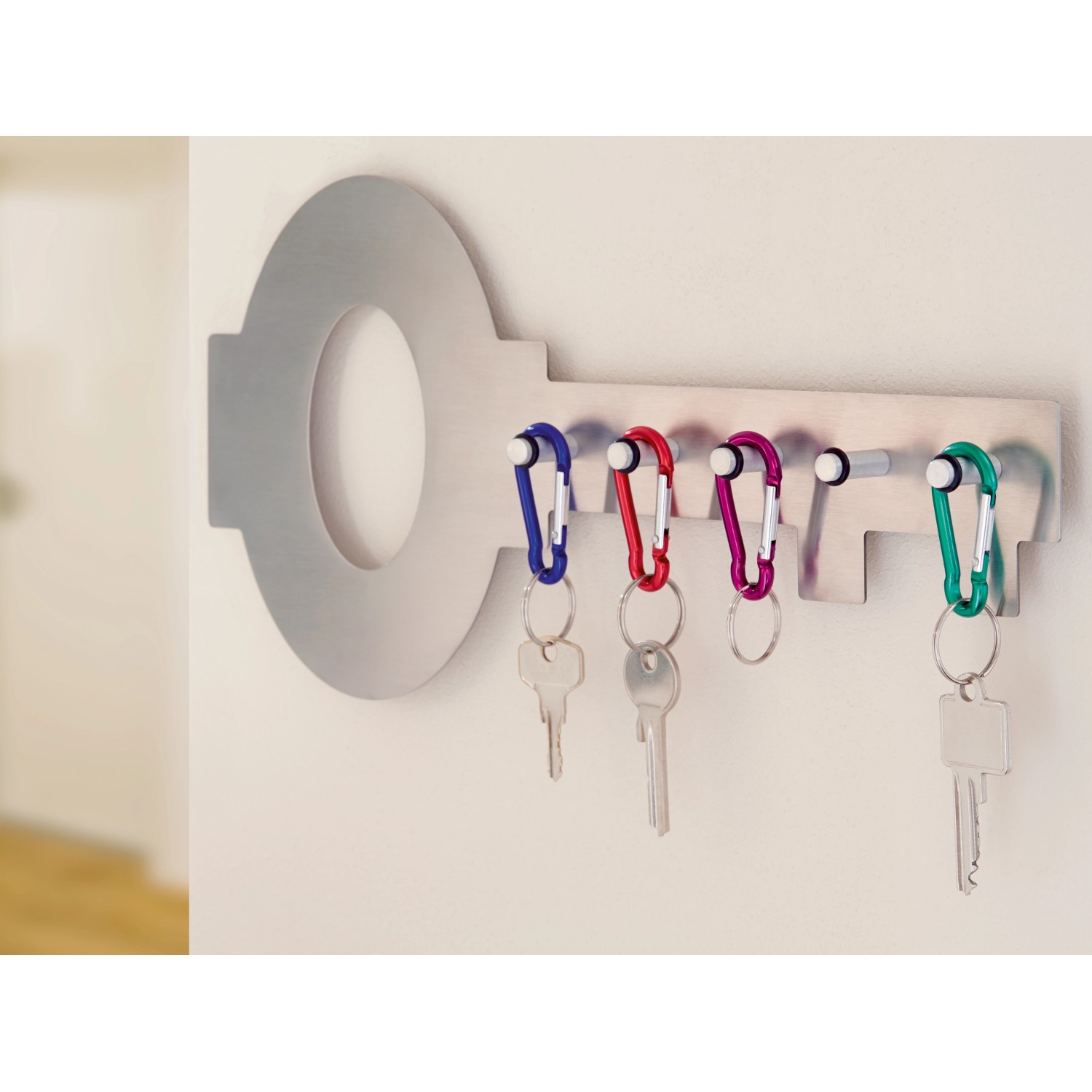 Karabinerhaken Set mit Schlüsselanhänger in Blau, Rot, Lila und Grün an Schlüsselbrett in Schlüsselform.