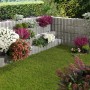 Bepflanzte graue Wellino Pflanzsteine als stufenförmige Hangbefestigung im Garten.