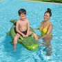 Kind auf Bestway Schwimmtier Krokodil im Pool, begleitet von Erwachsenem. Wasserspaß im Sommer!