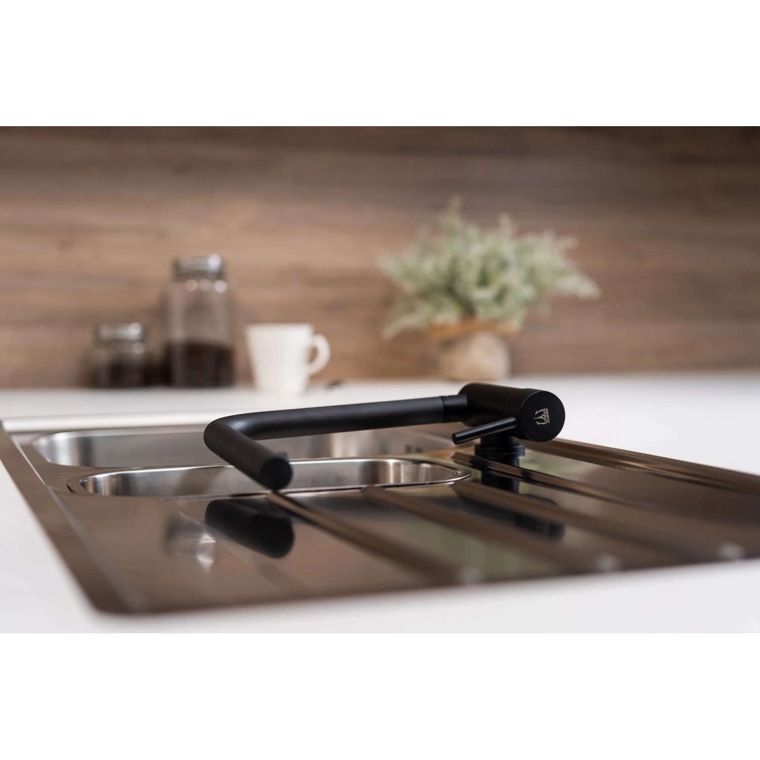 Schwarze VIZIO Küchenarmatur für Vorfenster-Montage mit schwenkbarem Auslauf auf einer Spüle.