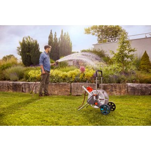Gardena CleverRoll L Easy Metall Schlauchwagen im Einsatz beim Bewässern eines Gartens.