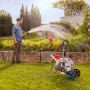 Gardena CleverRoll L Easy Metall Schlauchwagen im Einsatz beim Bewässern eines Gartens.