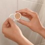Montage des schwarzen, matten Tesa Handtuchhakens Moon mit Klebelösung an der Wand.