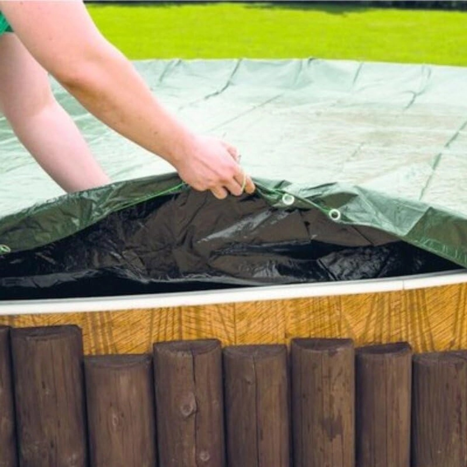 Poolomio Winterplane für runde Pools, grün/schwarz, wird über einen Pool gezogen.