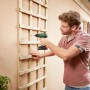 Bosch EasyDrill 18V-38 Akkuschrauber im Einsatz beim Schrauben eines Holzspaliers an einer Hauswand.