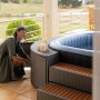 MSpa Tekapo AirJet aufblasbarer Whirlpool mit Hydromassage und Frau im Garten.