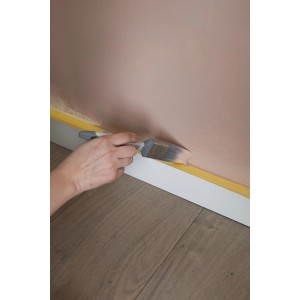 Hand streicht Wand mit Pinsel aus Wallpro Werkzeug-Set, Farbe Rosa.