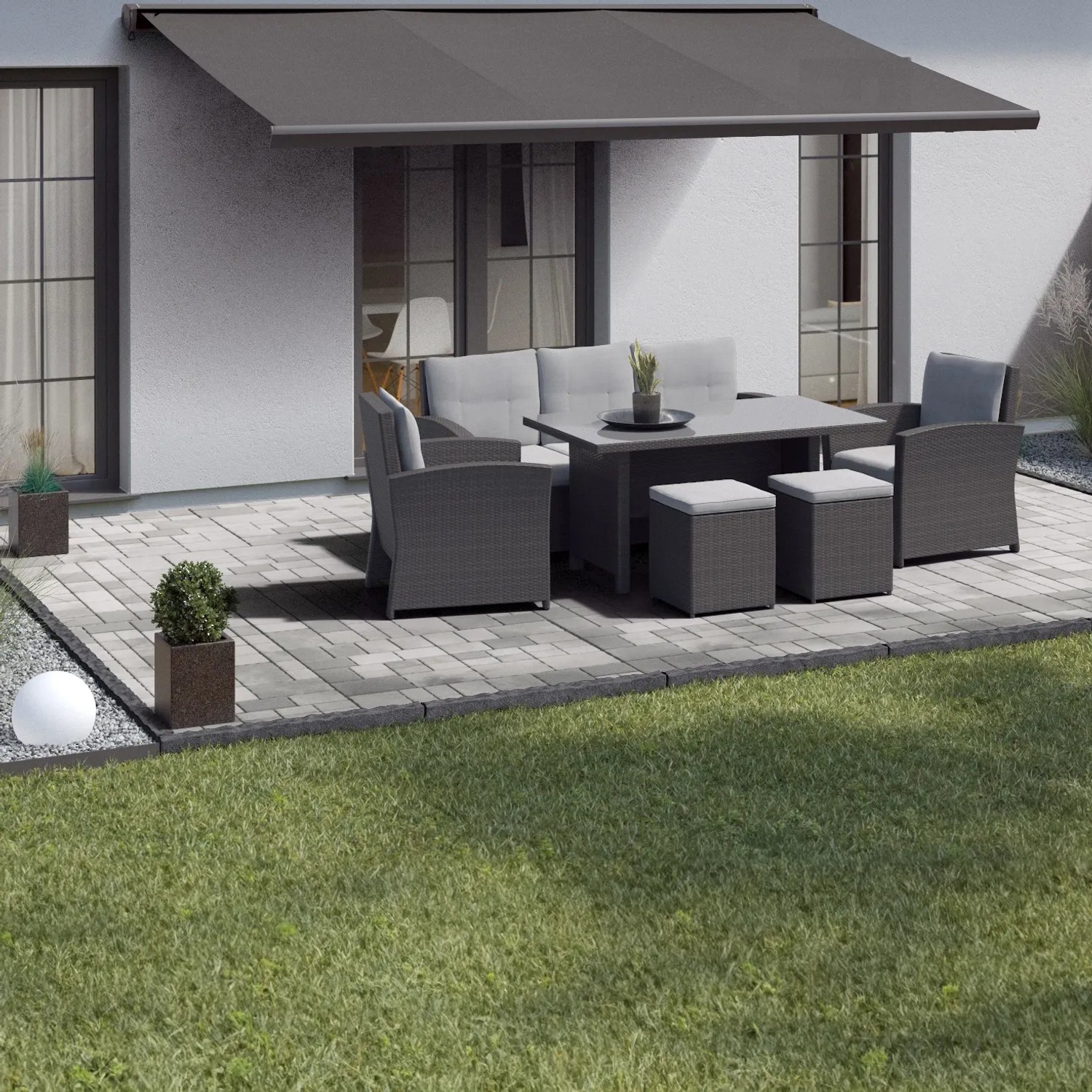 Verlegte graue Mehrformat-Pflastersteine Encanto Beton Antik mit Sitzgruppe auf Terrasse.
