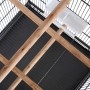 Innenansicht Vogelkäfig: Sitzstangen, Futternapf und Gitter des schwarzen Stahlkäfigs.