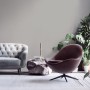 Wohnzimmer mit grauer Vliestapete, Sofa und Sessel. Dekorative Tapeten für ein gemütliches Zuhause.
