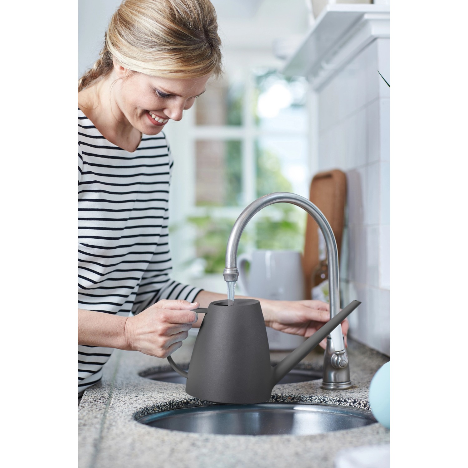 Frau befüllt anthrazitfarbene Elho Gießkanne Brussels (1,8 l) am Wasserhahn.