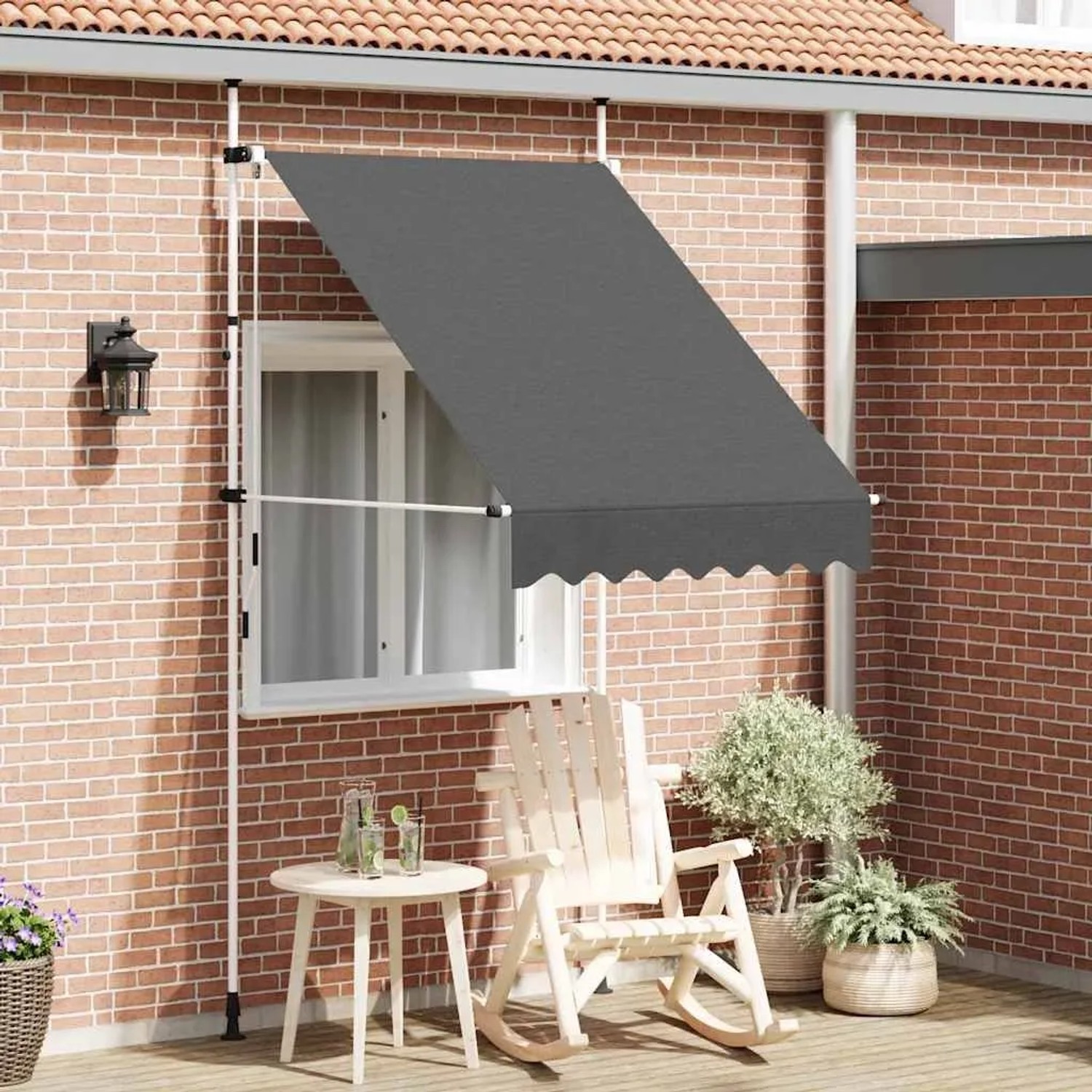 Anthrazitfarbene, handbetriebene Einziehmarkise (150 cm) am Haus mit Gartenmöbeln.