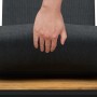 Detailaufnahme: Hand auf Sitzkissen des schwarzen Lounge-Sets aus Akazienholz.