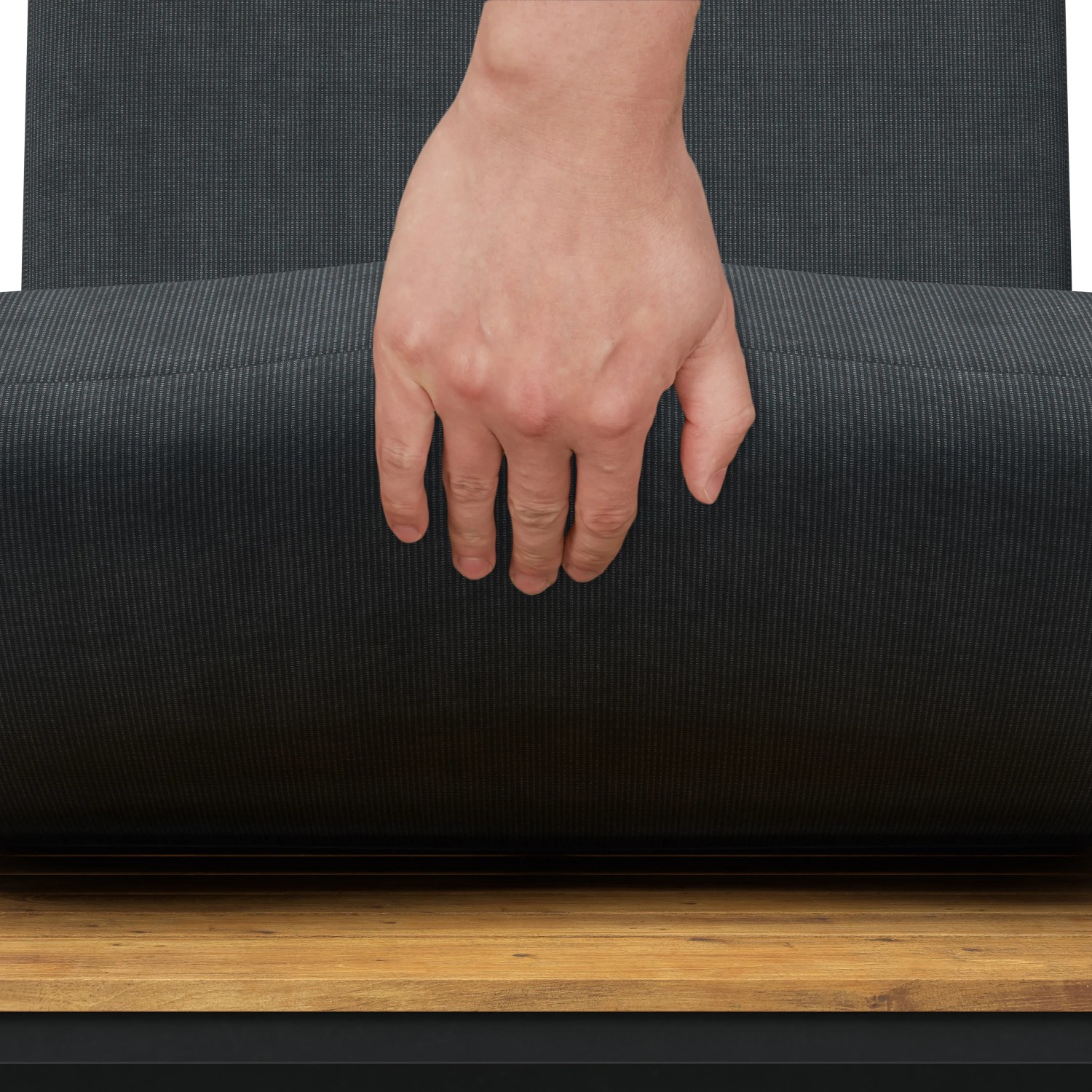 Detailaufnahme: Hand auf Sitzkissen des schwarzen Lounge-Sets aus Akazienholz.