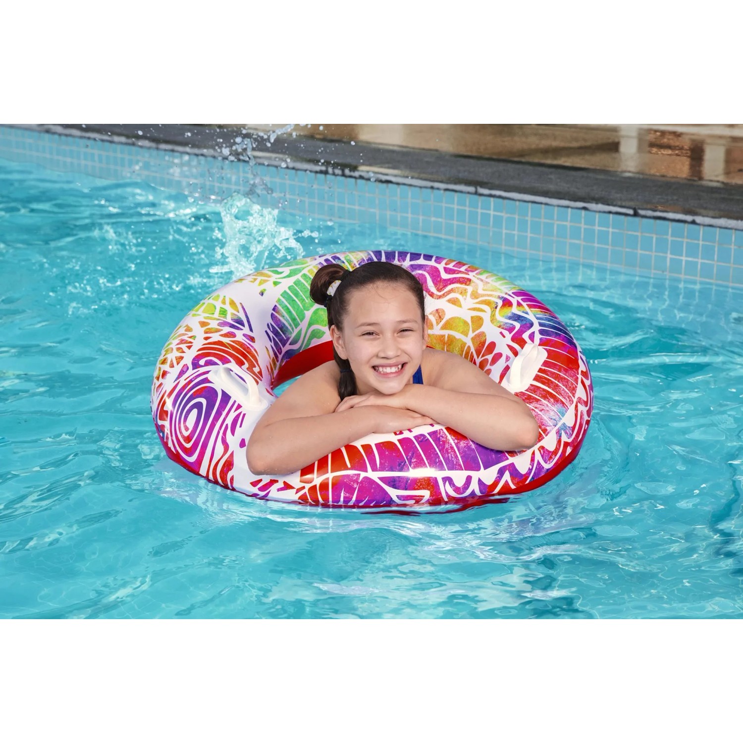 Mädchen im Pool mit buntem Bestway Schwimmring Summer Swirl (Ø 80 cm) mit Mandala-Design.