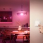 Philips Hue Tap Dial Schalter in Weiß an Wand, steuert farbige Lampe im Esszimmer.