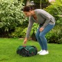 Frau bedient grünen Bosch Mähroboter VISIMOW 18V-100 auf Rasenfläche im Garten.