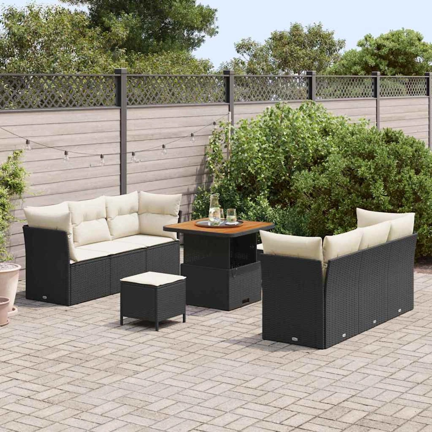 9-teiliges Garten-Sofa-Set aus schwarzem Rattan mit Tisch und cremefarbenen Kissen.