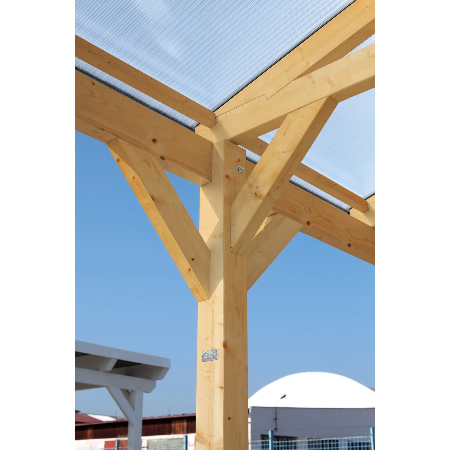 Detailansicht des weißen Skan Holz Carport Westerwald mit Holzpfosten und transparentem Dach.