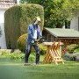 Mann sägt Holz mit der Kärcher Akku-Kettensäge CNS 18-30 im Garten.