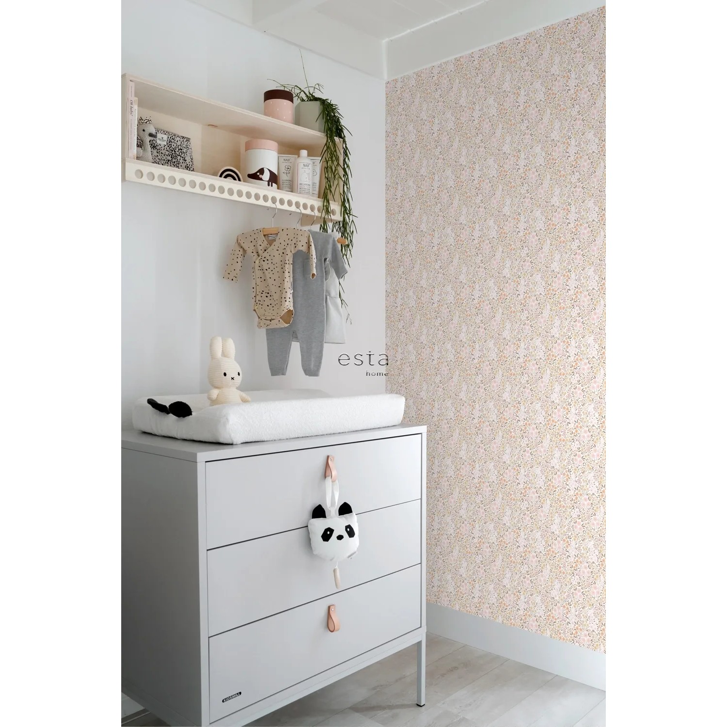 ESTAhome Vliestapete mit zartem Blumenmuster in Hellrosa und Beige an der Wand eines Kinderzimmers.