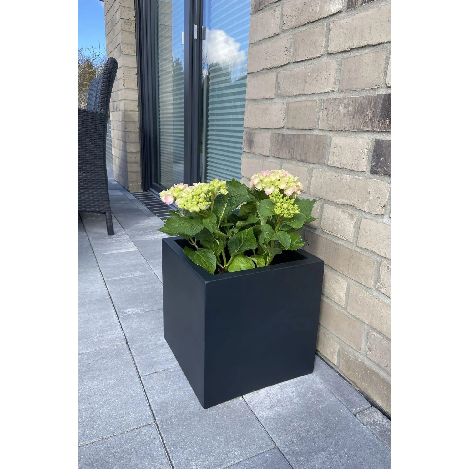 Anthrazitfarbener Vivanno Pflanzkübel Block 30x30x30 cm mit Pflanze auf einer Terrasse.