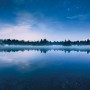 Komar Fototapete Vlies Glistening Stars: Winterlandschaft mit See und Sternenhimmel.