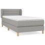 Helles Boxspringbett 100x200 cm mit Matratze und Kopfteil, grauer Stoffbezug.
