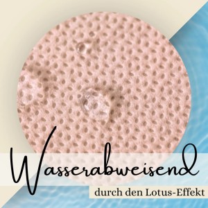 Nahaufnahme einer creme Sensalux Tischdecke: Wasser perlt dank Lotuseffekt ab.