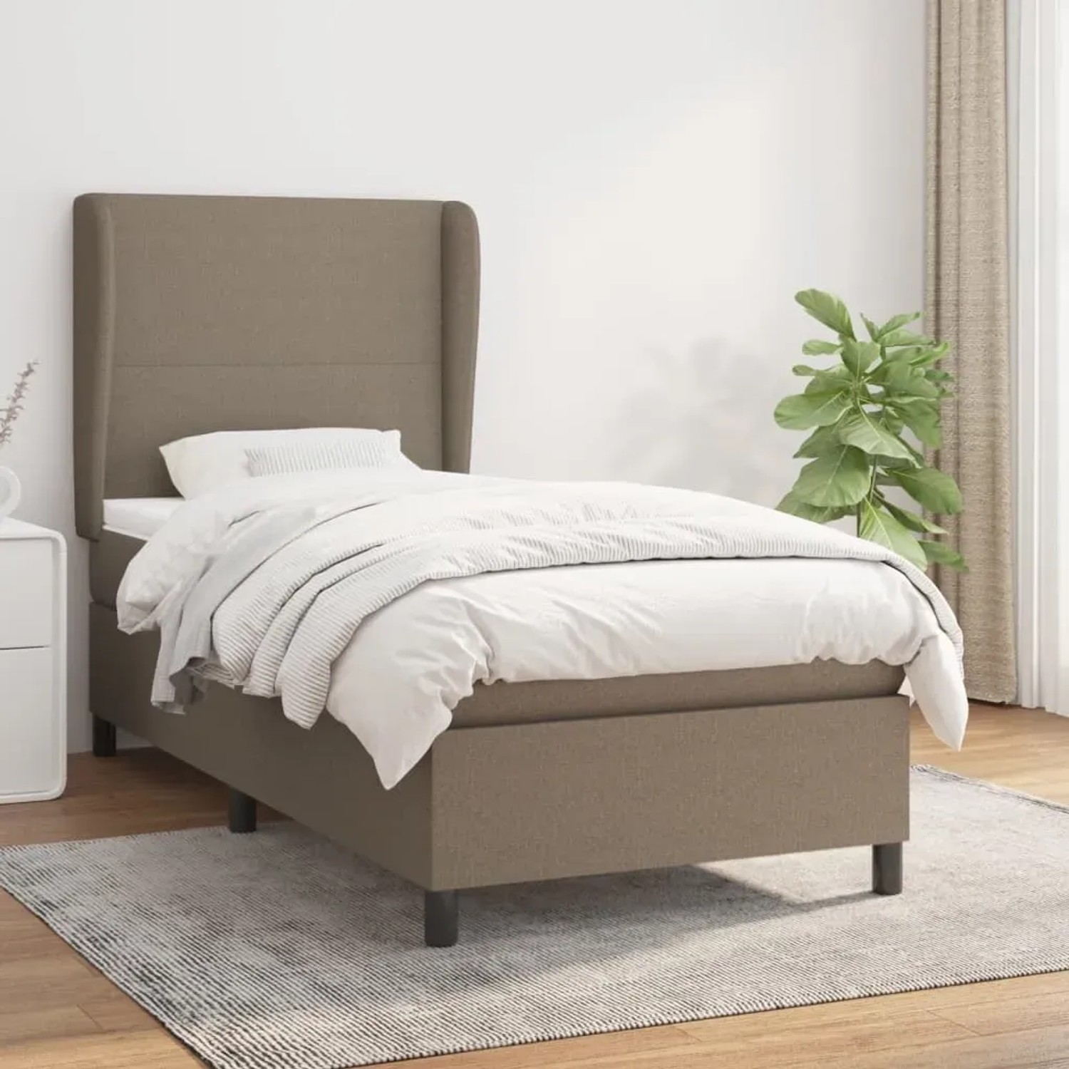 Taupes Boxspringbett 90x190 cm mit Matratze und hohem Kopfteil im Schlafzimmer.