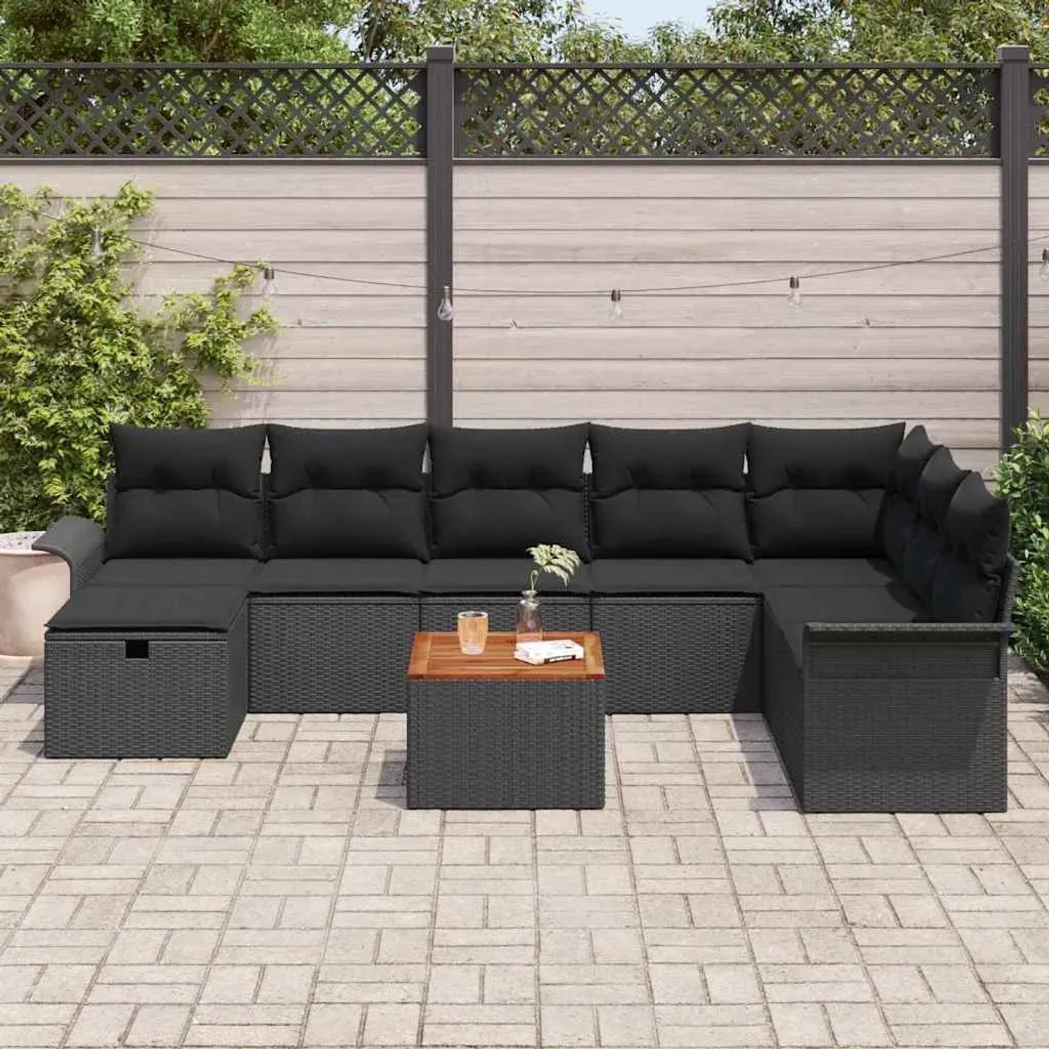 Schwarzes 9-teiliges Garten-Sofa-Set aus Poly Rattan mit Kissen und Tisch.