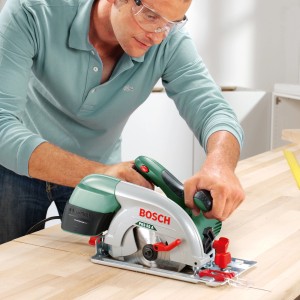 Bosch PKS 55 A Handkreissäge im Einsatz auf Holz, 1200 W Leistung.