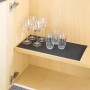 Schwarze Wenko Anti-Rutsch-Matte (150x50 cm) im Küchenschrank mit Gläsern.