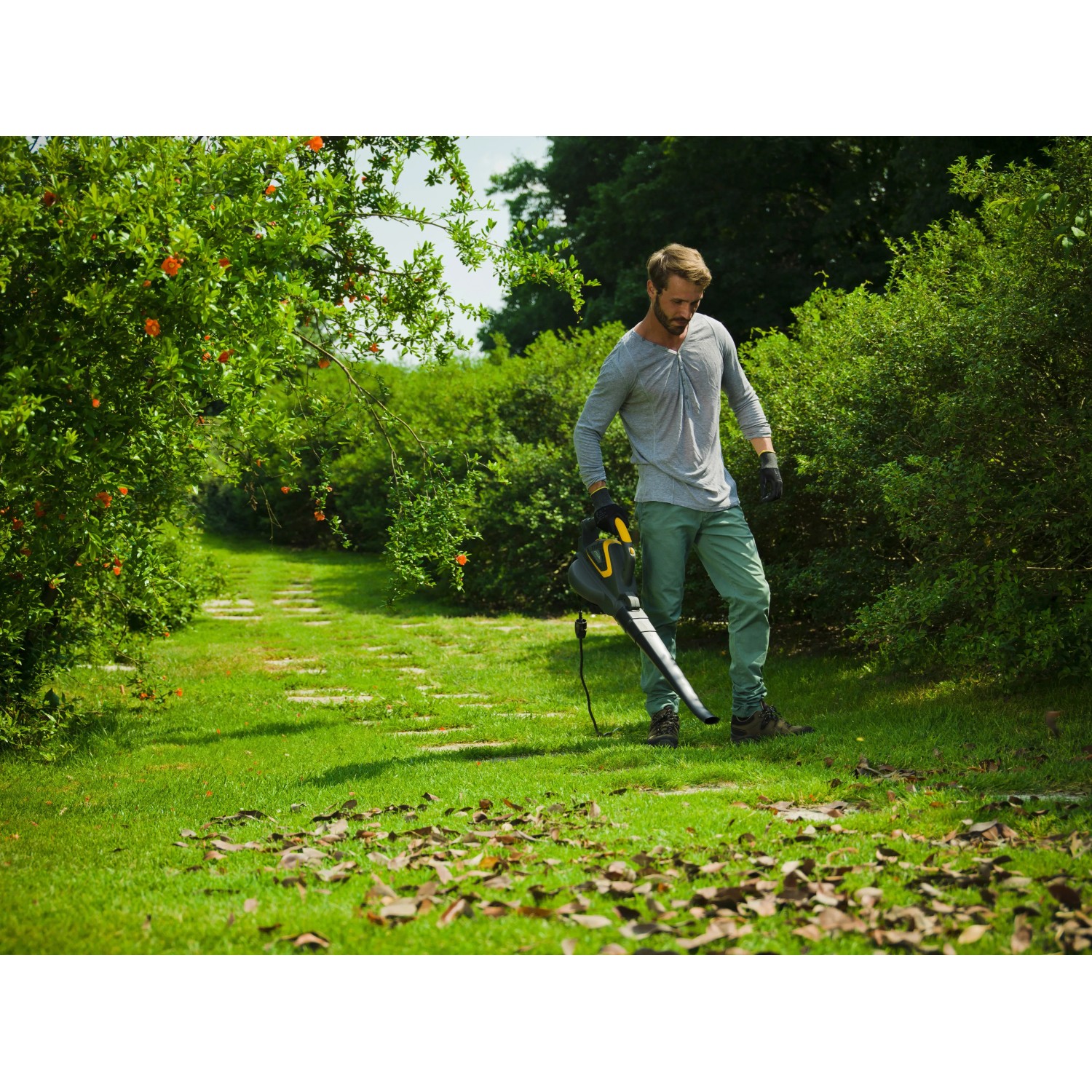 Mann benutzt Stiga Elektro-Laubbläser BL 130c V im Garten.