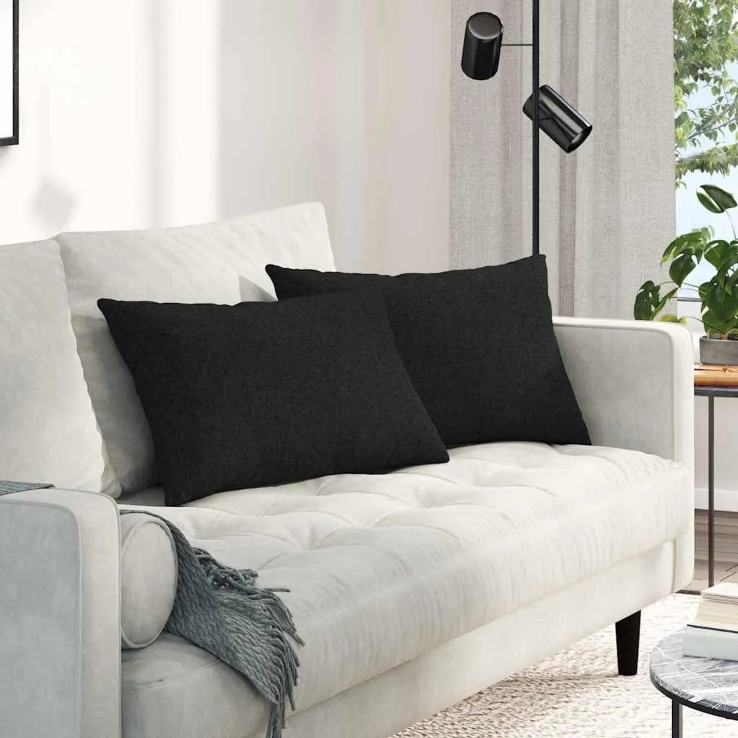 Zwei schwarze Sofakissen (60x40 cm) aus Stoff von vidaXL auf einem weißen Sofa.