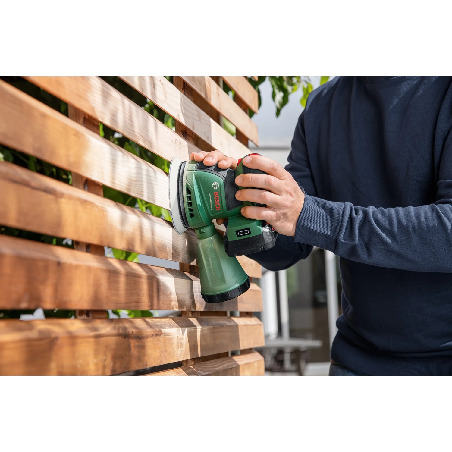 Bosch Akku-Exzenterschleifer UniversalOrbit 18V-20 im Einsatz beim Schleifen von Holz.