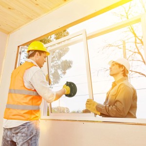 Handwerker montieren Fenster mit schwarzem Vakuum Saugheber aus Kunststoff. Glassauger zum Heben von Scheiben.