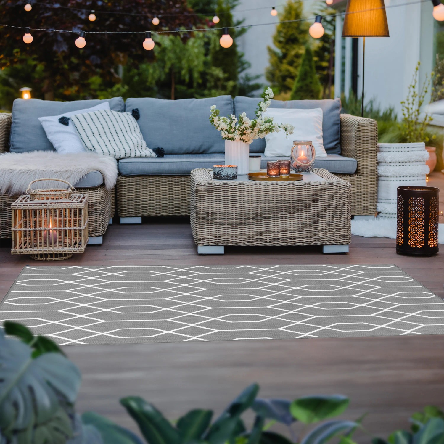 Grauer Primaflor In- und Outdoorteppich Reverso Geo River (160x220cm) auf einer Terrasse.