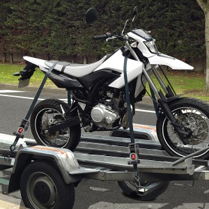 Motorrad auf Anhänger mit Master Lock Zurrgurt 3248EURDAT gesichert.