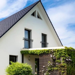 Anthrazitfarbener, französischer Balkon (128x90cm) mit 9 Füllstäben am weißen Haus.