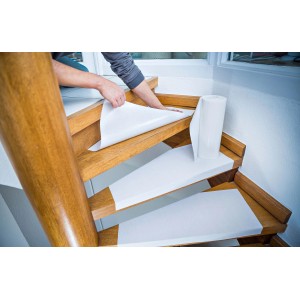 Anbringen von LUX Treppenvlies (8,25 m²) auf einer Holztreppe zum Schutz vor Beschädigungen.