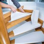 Anbringen von LUX Treppenvlies (8,25 m²) auf einer Holztreppe zum Schutz vor Beschädigungen.